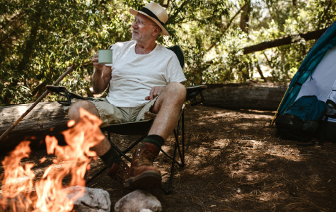 Person sitting next to a campfire